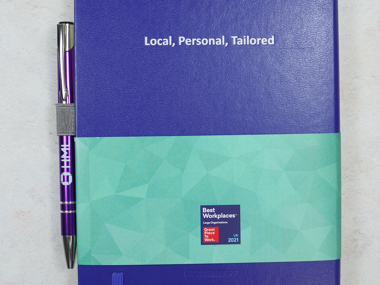 White foil print of HML slogan "Local, Personal, Tailored" on the back of a purple Leuchtturm notebook as part of the stationery sets.
